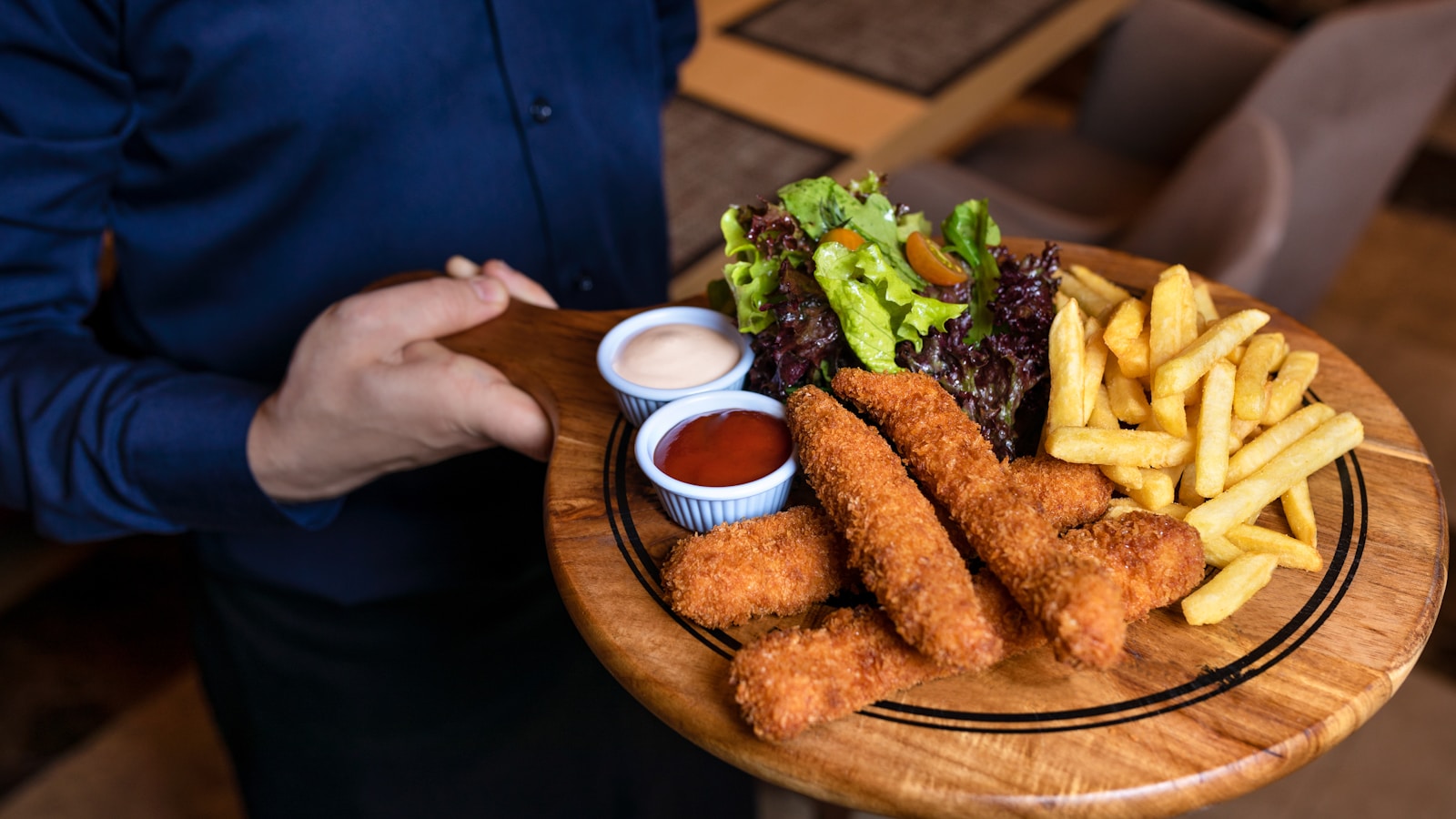 fried food with green vegetable on brown wooden round plate